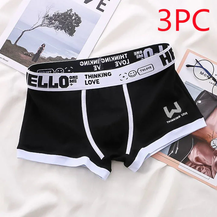 Black men's boxer briefs with white trim, printed waistband with text and smiley face icons, displayed on white surface