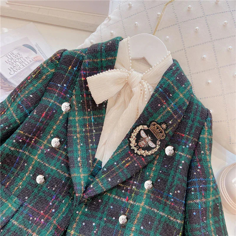 Green and black plaid tweed blazer with silver buttons, bee and crown brooch, and ivory bow blouse