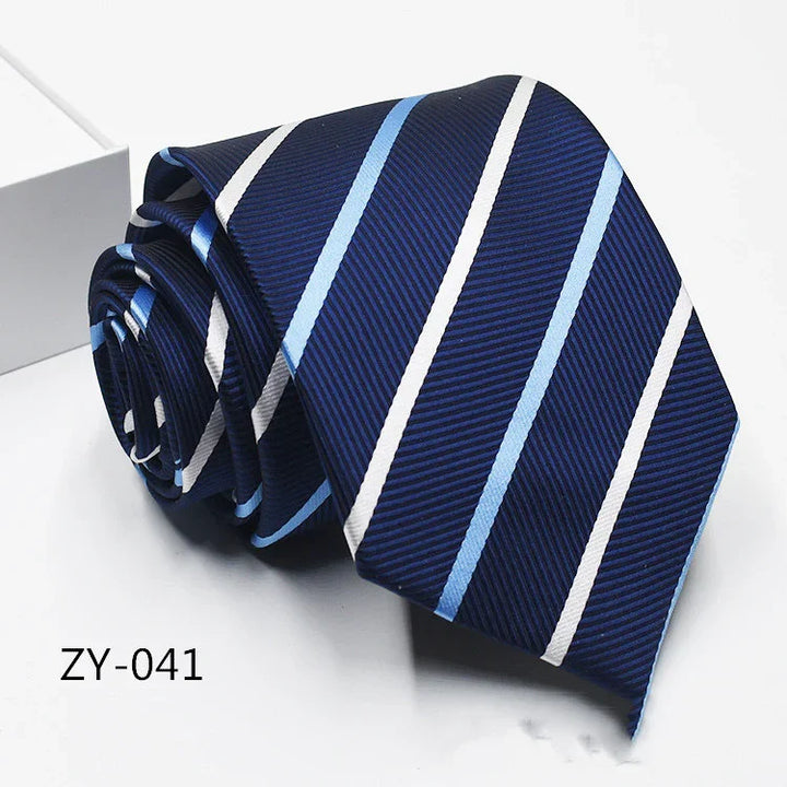 Navy blue striped men's necktie with light blue and white diagonal stripes, rolled up on white surface