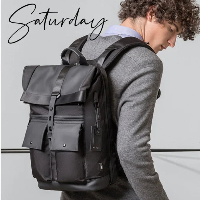 Young man wearing a black, stylish backpack with multiple pockets and leather accents, gray sweater