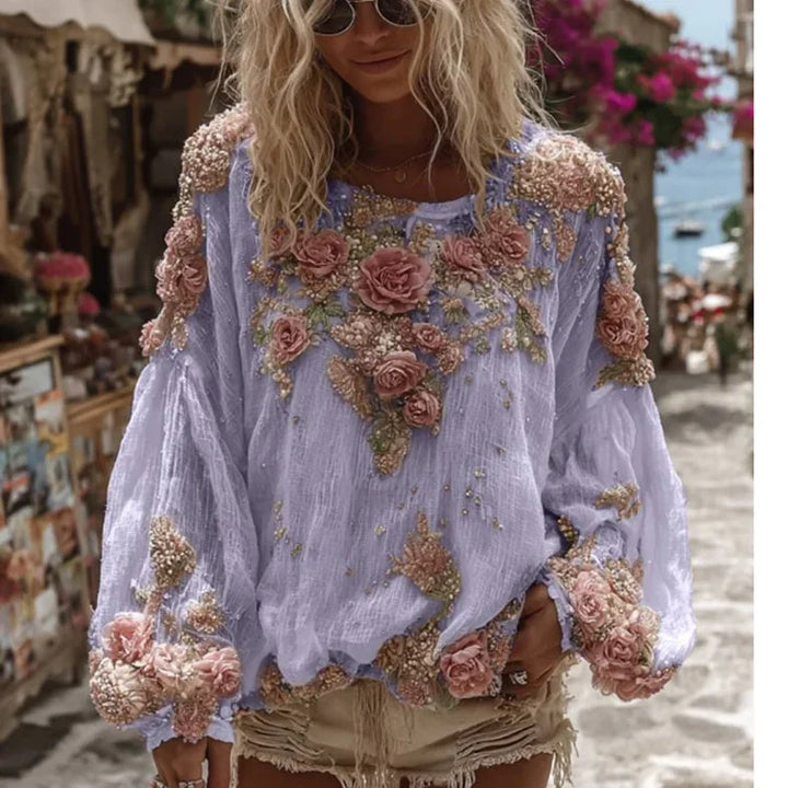 Blonde woman wearing lilac blouse with pink floral embroidery and beige shorts on a sunny street