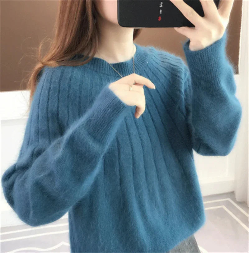 Woman wearing soft blue ribbed knit sweater taking mirror selfie with smartphone