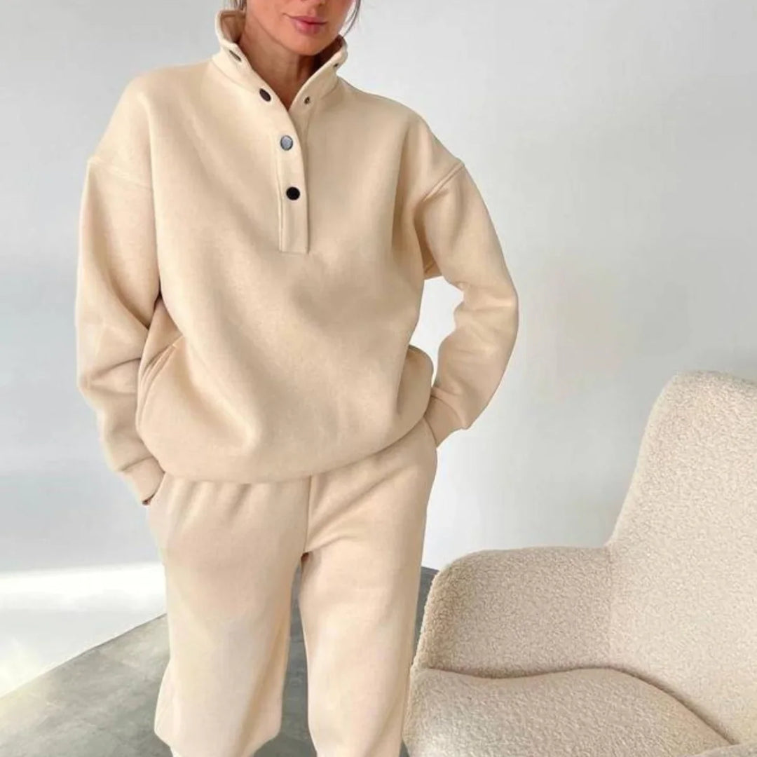 Woman wearing beige cozy fleece pullover with snap buttons and matching pants indoors