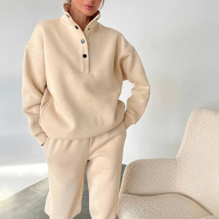 Woman wearing beige cozy fleece pullover with snap buttons and matching pants indoors