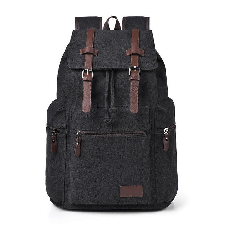 Black canvas backpack with brown leather straps and front zippered pockets, minimalist design