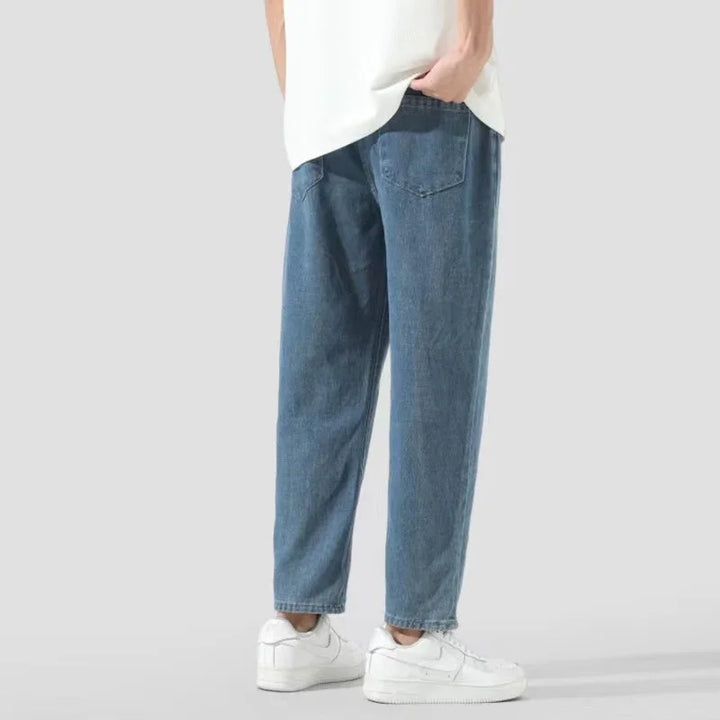 Casual blue denim jeans with elastic waistband worn with white sneakers and a white shirt