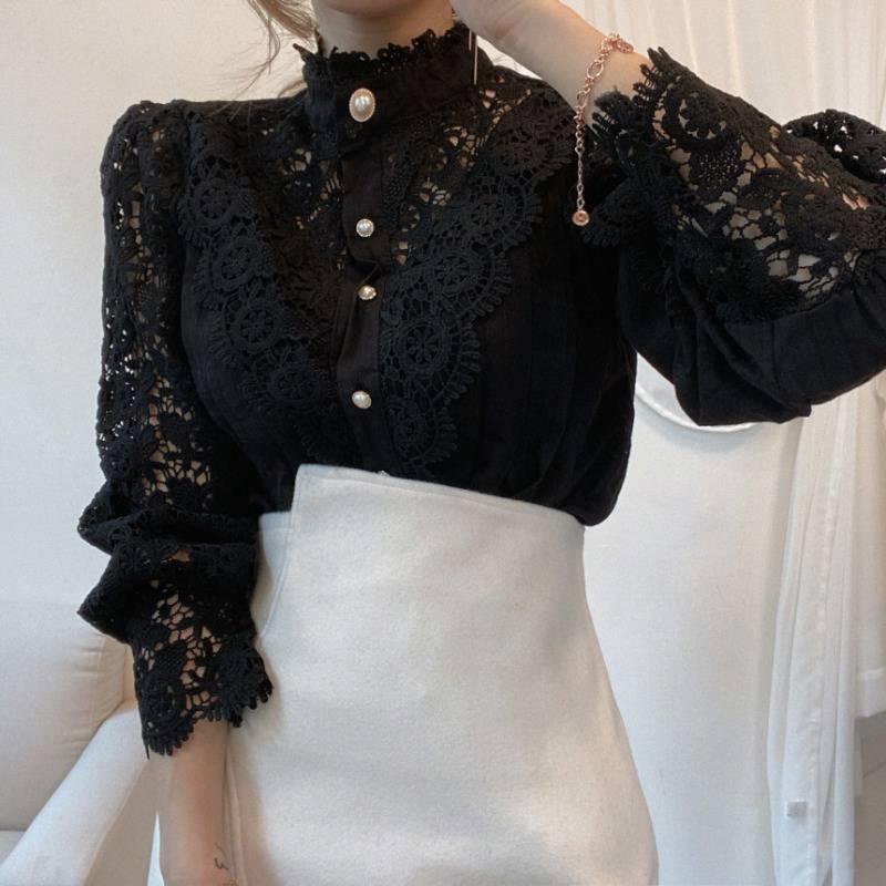 Woman wearing elegant black lace blouse with pearl buttons and white high-waisted skirt
