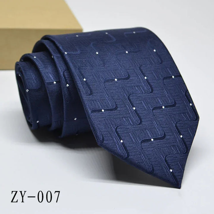 Navy blue men's silk tie with geometric pattern and white dot accents, elegant formal accessory