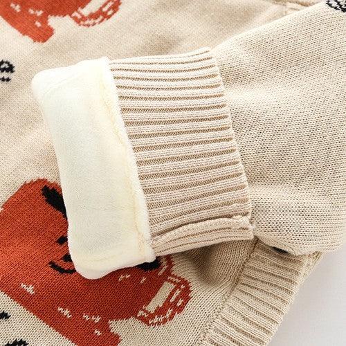 Close-up of beige knit sweater cuff with soft white lining on red dog print fabric