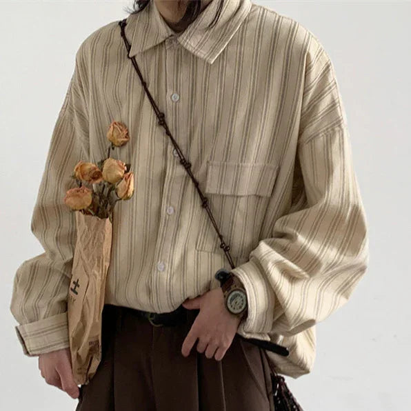 Person wearing beige striped button-up shirt with clock watch and holding dried flowers wrapped in brown paper