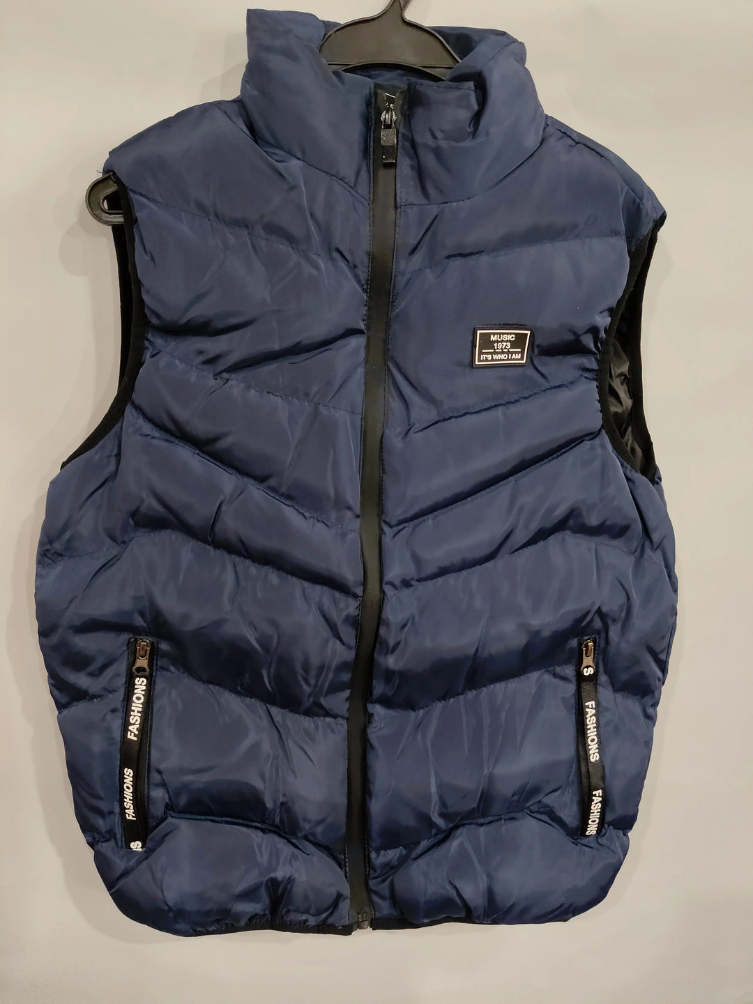 Navy blue puffer vest with zipper and pockets, featuring a music-themed patch on chest