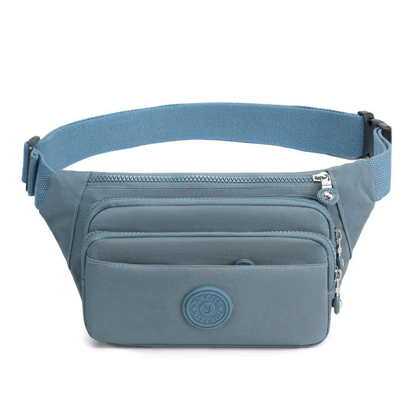 Blue fabric waist bag with multiple zippered compartments and adjustable strap