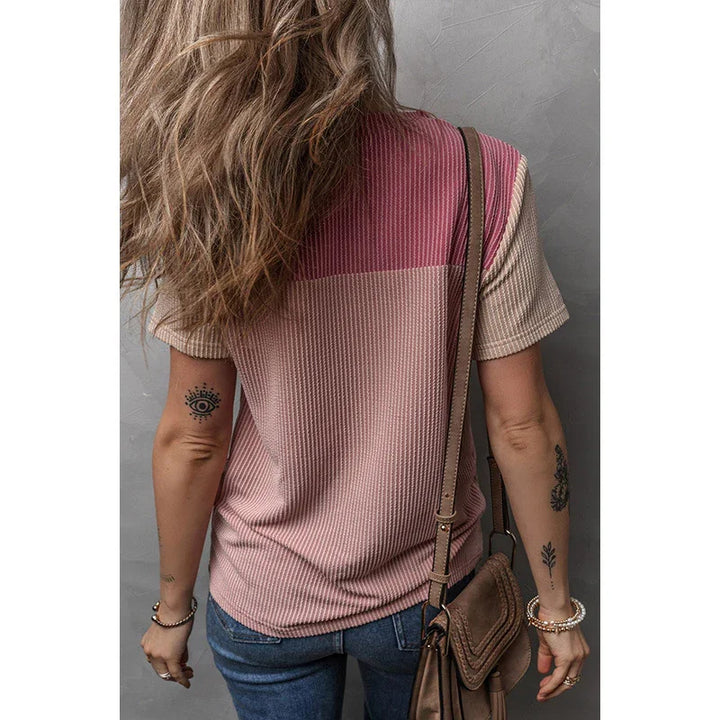 woman wearing pink and beige color block short sleeve top with blue jeans and brown crossbody bag