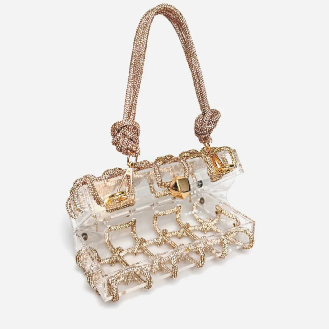 Transparent handbag with gold-tone chain detailing and knotted handles on white background