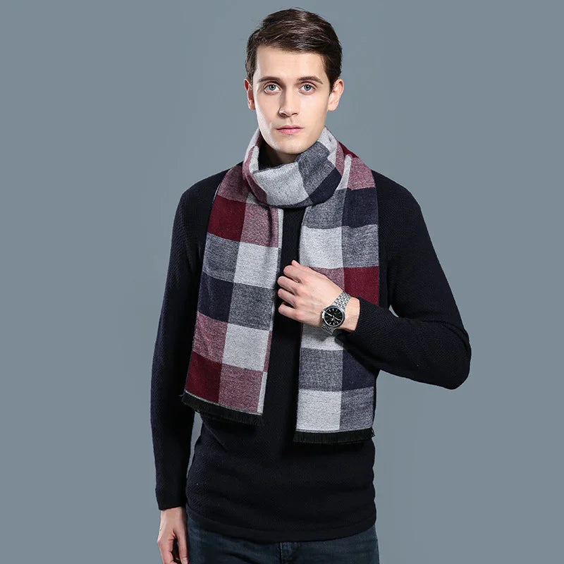 Young man wearing black sweater and stylish multicolor checkered scarf against gray background