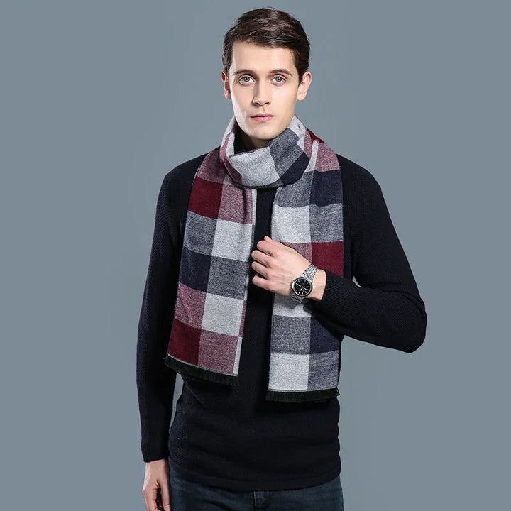 Young man wearing black sweater and stylish multicolor checkered scarf against gray background