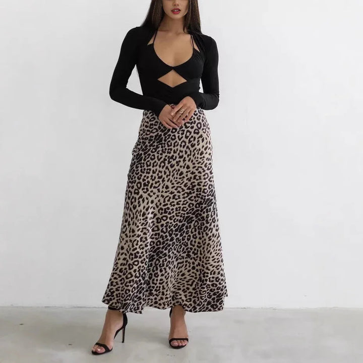 Woman wearing black long sleeve cutout top and leopard print maxi skirt with black high heels