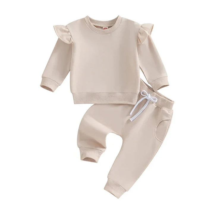 Beige toddler outfit with ruffled shoulder sweatshirt and drawstring pants on white background