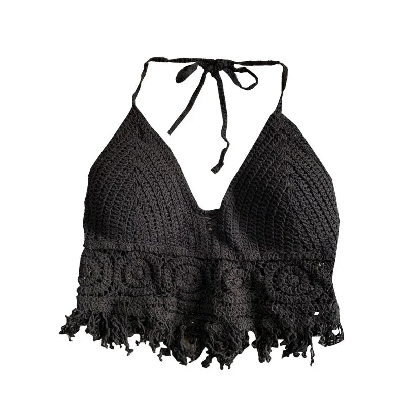 Black crochet halter top with floral pattern and fringe hem, isolated on white background