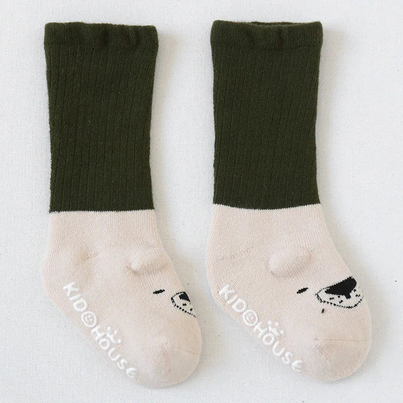 Pair of children's socks with dark green ribbed cuffs and beige feet, featuring bear face design and KidHouse logo