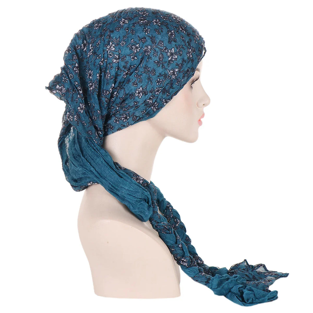 Side view of mannequin wearing a blue floral patterned headscarf with braided ends