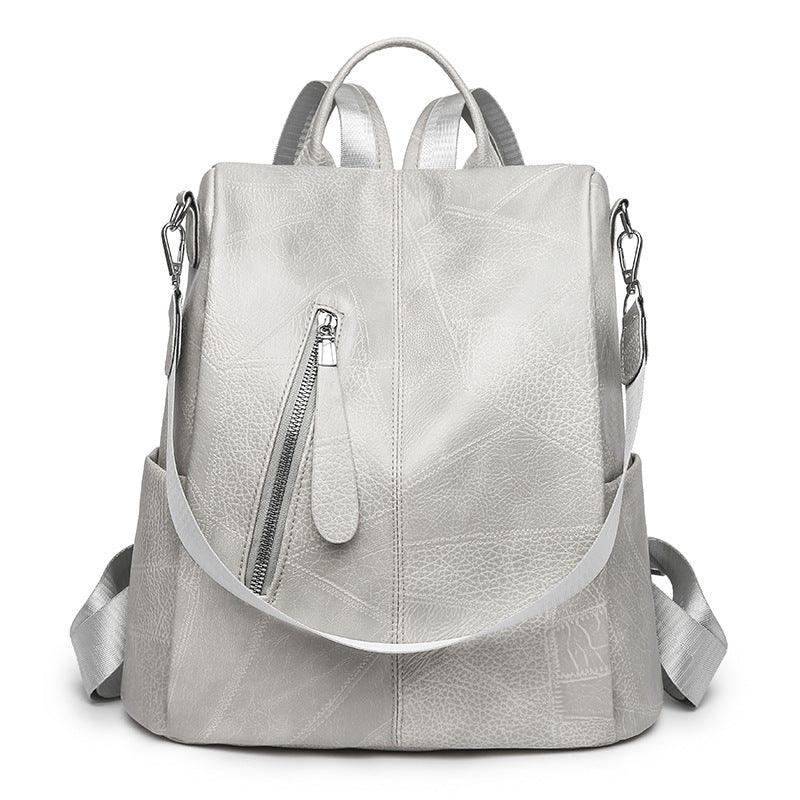 Light grey textured leather backpack with front zip pocket and adjustable shoulder straps