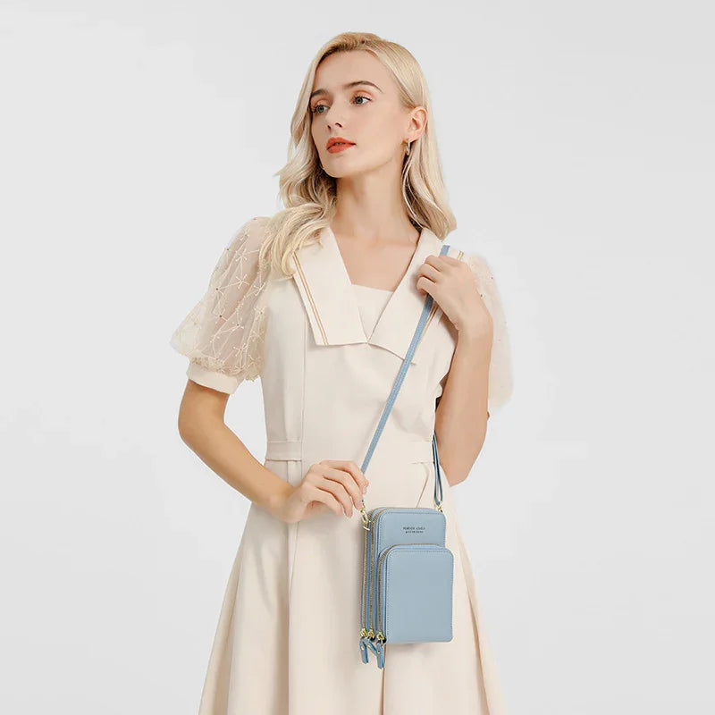 Blonde woman in cream dress with sheer puff sleeves holding light blue crossbody purse against white background