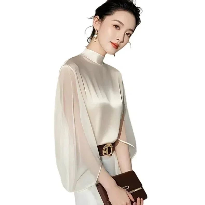 Elegant woman in white satin blouse with sheer sleeves, holding brown clutch bag