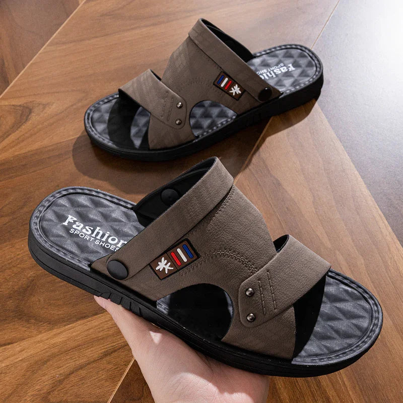 Brown casual sport sandals with black cushioned soles on wooden surface