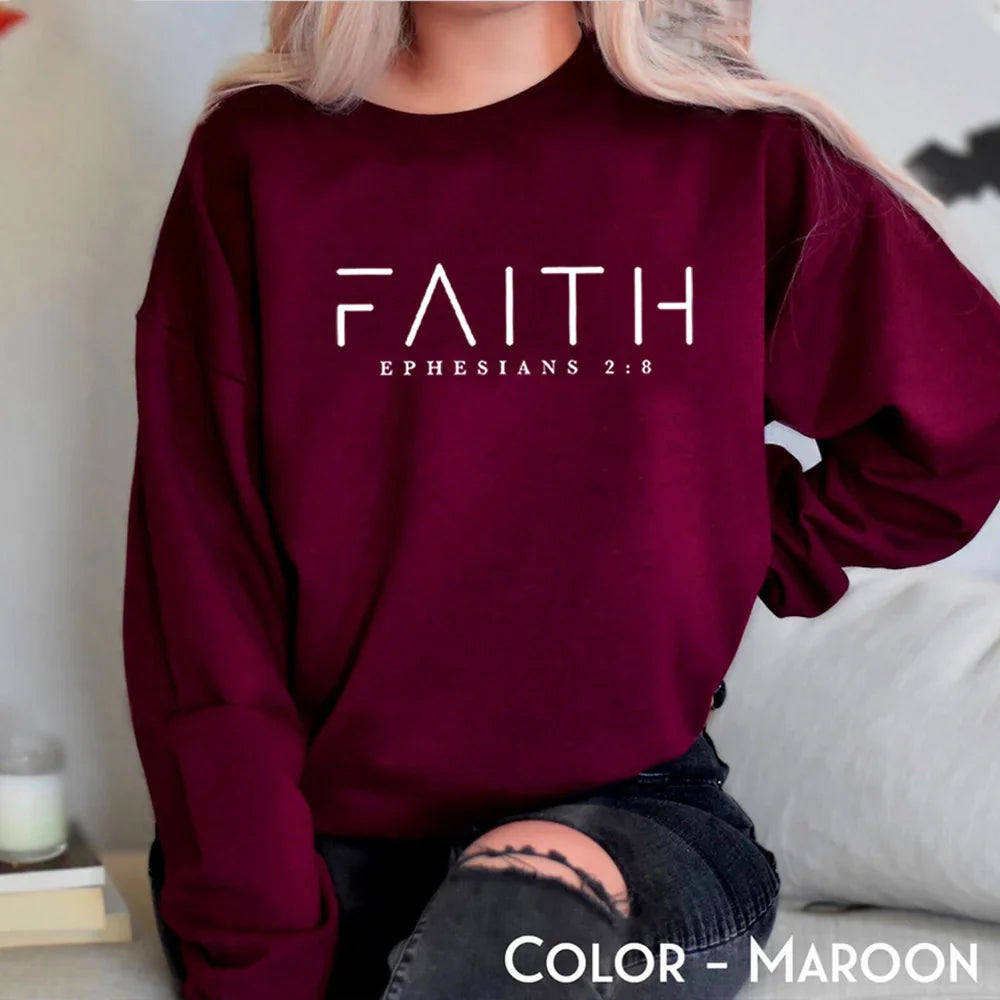 Maroon sweatshirt with FAITH and EPHESIANS 2:8 text worn by a seated person with ripped jeans