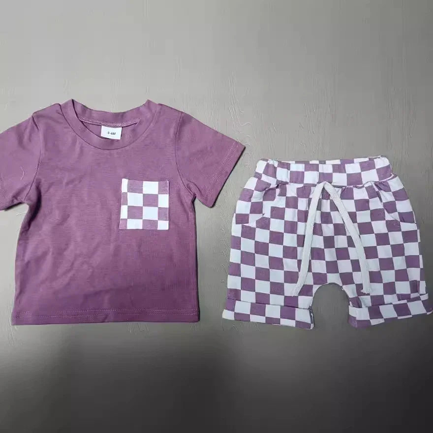Purple toddler outfit with checkered pocket t-shirt and matching checkered shorts on gray surface