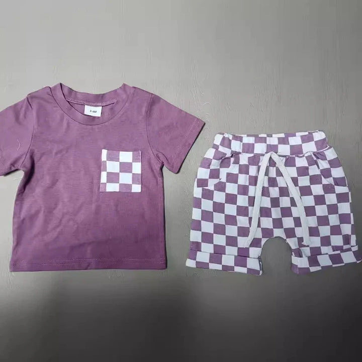 Purple toddler outfit with checkered pocket t-shirt and matching checkered shorts on gray surface