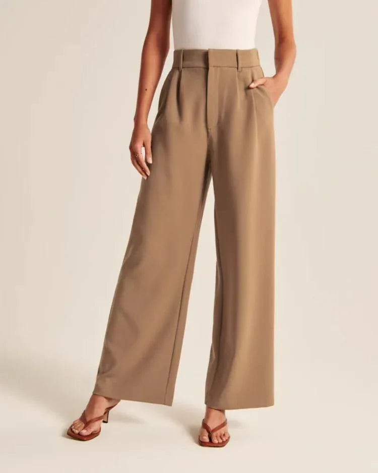 Woman wearing high-waisted wide-leg tan pants paired with brown heeled sandals