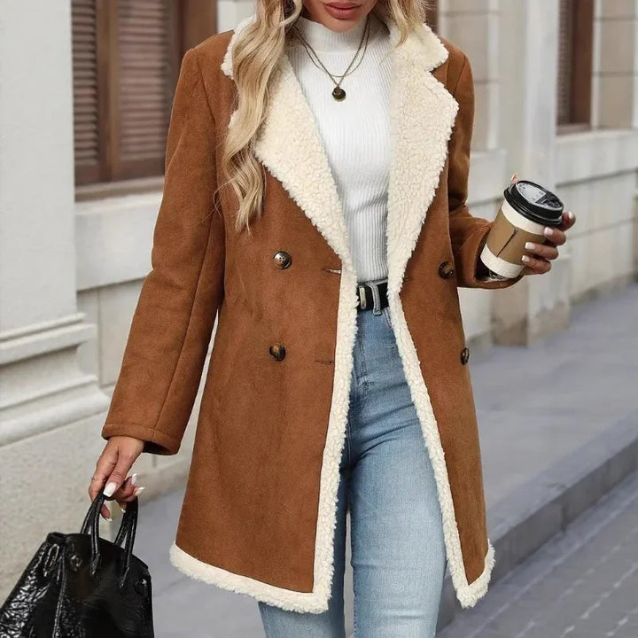 woman wearing brown sherpa-lined coat with white turtleneck, blue jeans, holding coffee cup and black handbag