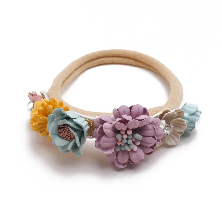 Beige elastic hairband decorated with pastel fabric flowers in yellow, light blue, purple, and beige