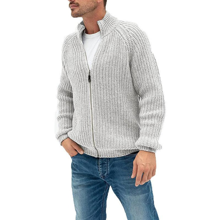man wearing light gray chunky knit zip-up sweater with high collar and blue jeans