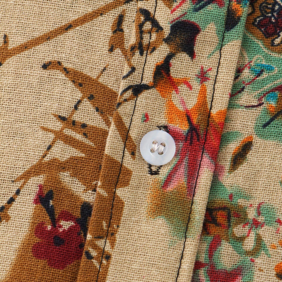 Close-up of floral fabric with brown, red, orange, and green patterns and a white button detail