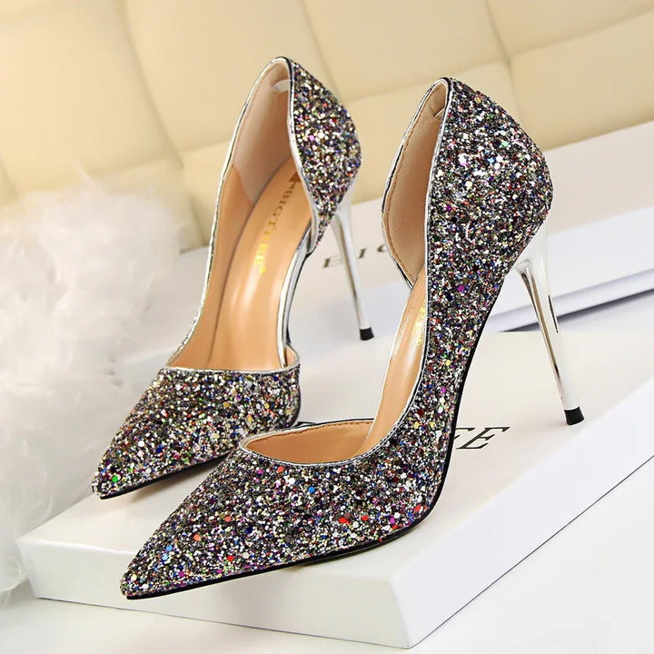 Pair of sparkling multicolor glitter high heels with silver stiletto heels on white box