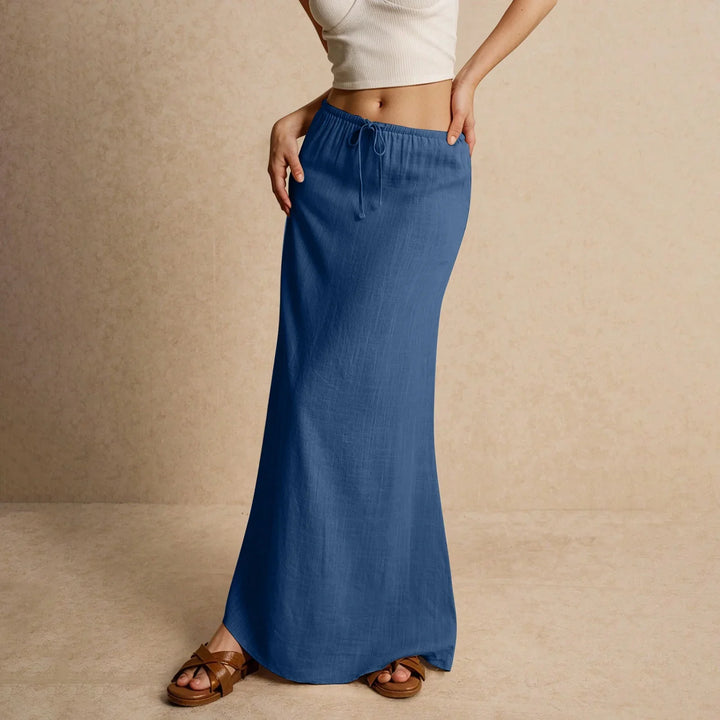 Woman wearing blue drawstring maxi skirt with beige crop top and brown sandals
