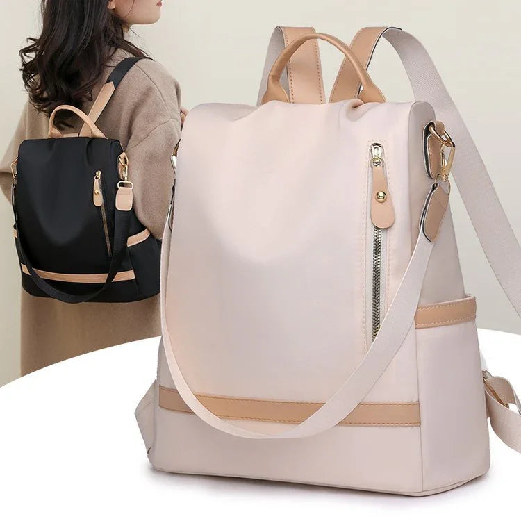 Stylish beige and black nylon backpacks with tan leather accents worn by women, featuring zippered pockets and adjustable straps
