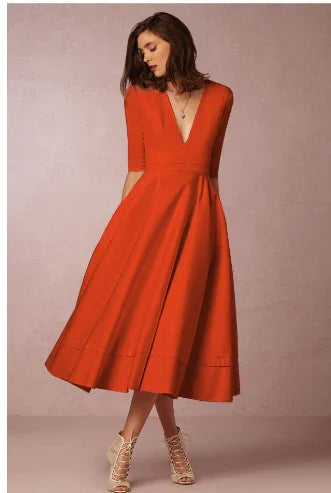 Woman in elegant red midi dress with deep V-neck and 3/4 sleeves against beige background