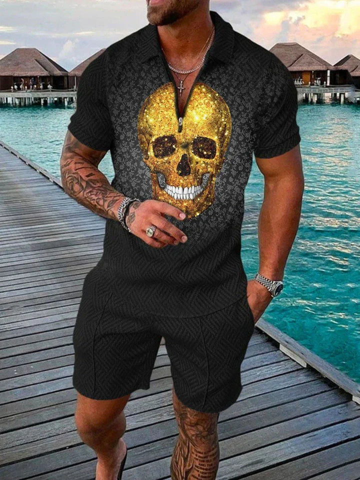 Muscular man in black shorts and shirt with large gold skull print standing on dock by turquoise ocean and thatched huts