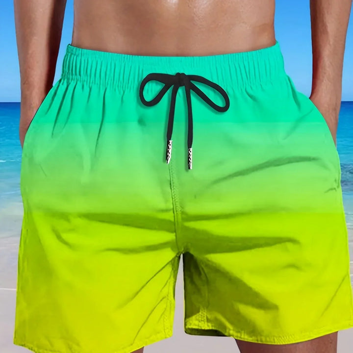 Close-up of man wearing green and yellow gradient swim trunks with black drawstring at the beach