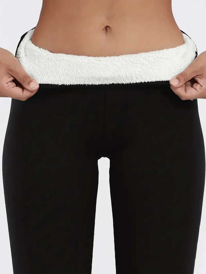 Close-up of person wearing black leggings with soft white fleece lining at the waist