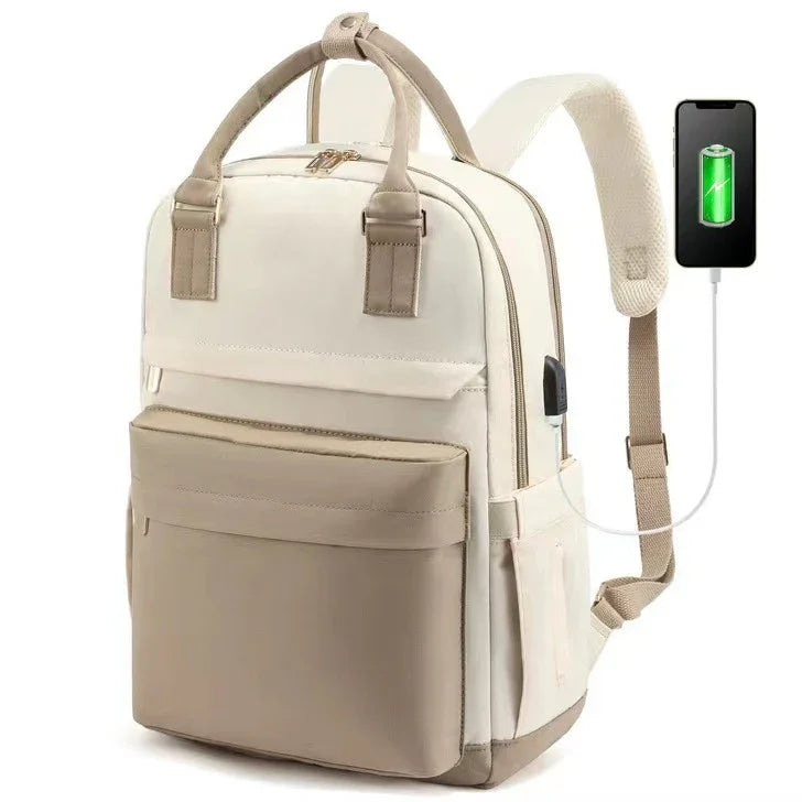 Beige and cream backpack with front pocket and USB charging port connected to a smartphone
