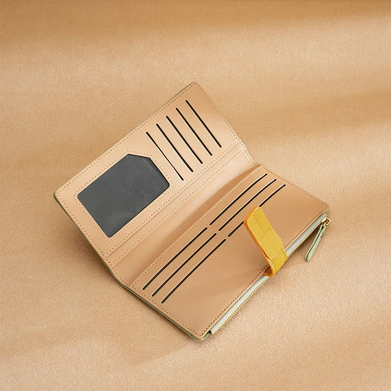 Open tan leather wallet with multiple card slots, ID window, yellow snap closure, and zippered compartment