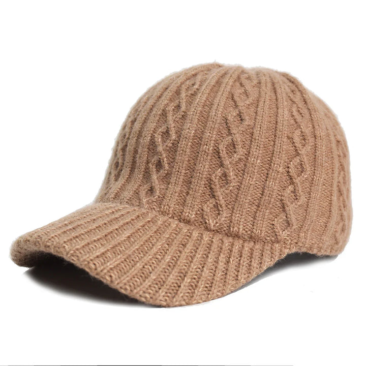 Beige knitted wool baseball cap with cable knit pattern and ribbed brim on white background