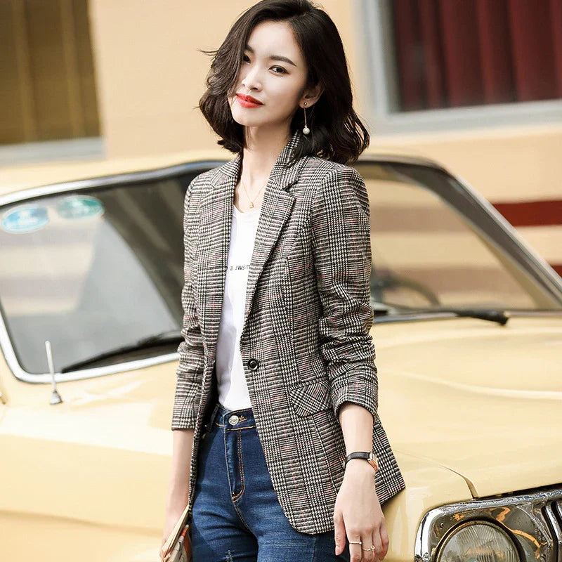 Woman wearing checked blazer and jeans leaning on vintage yellow car outdoors