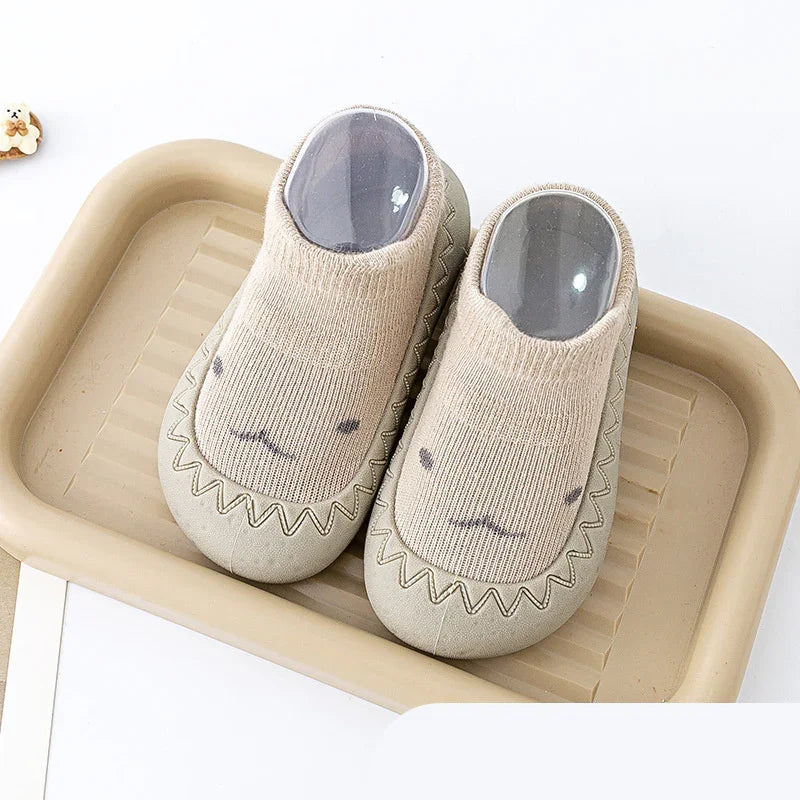 Beige soft indoor slippers with cute animal face design placed on a matching beige tray