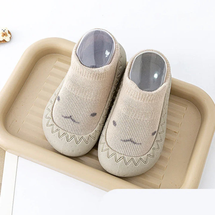 Beige soft indoor slippers with cute animal face design placed on a matching beige tray